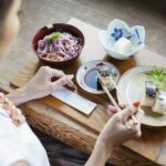 High angle view of Japanese woman sitting at a table in a Japanese restaurant, eating.