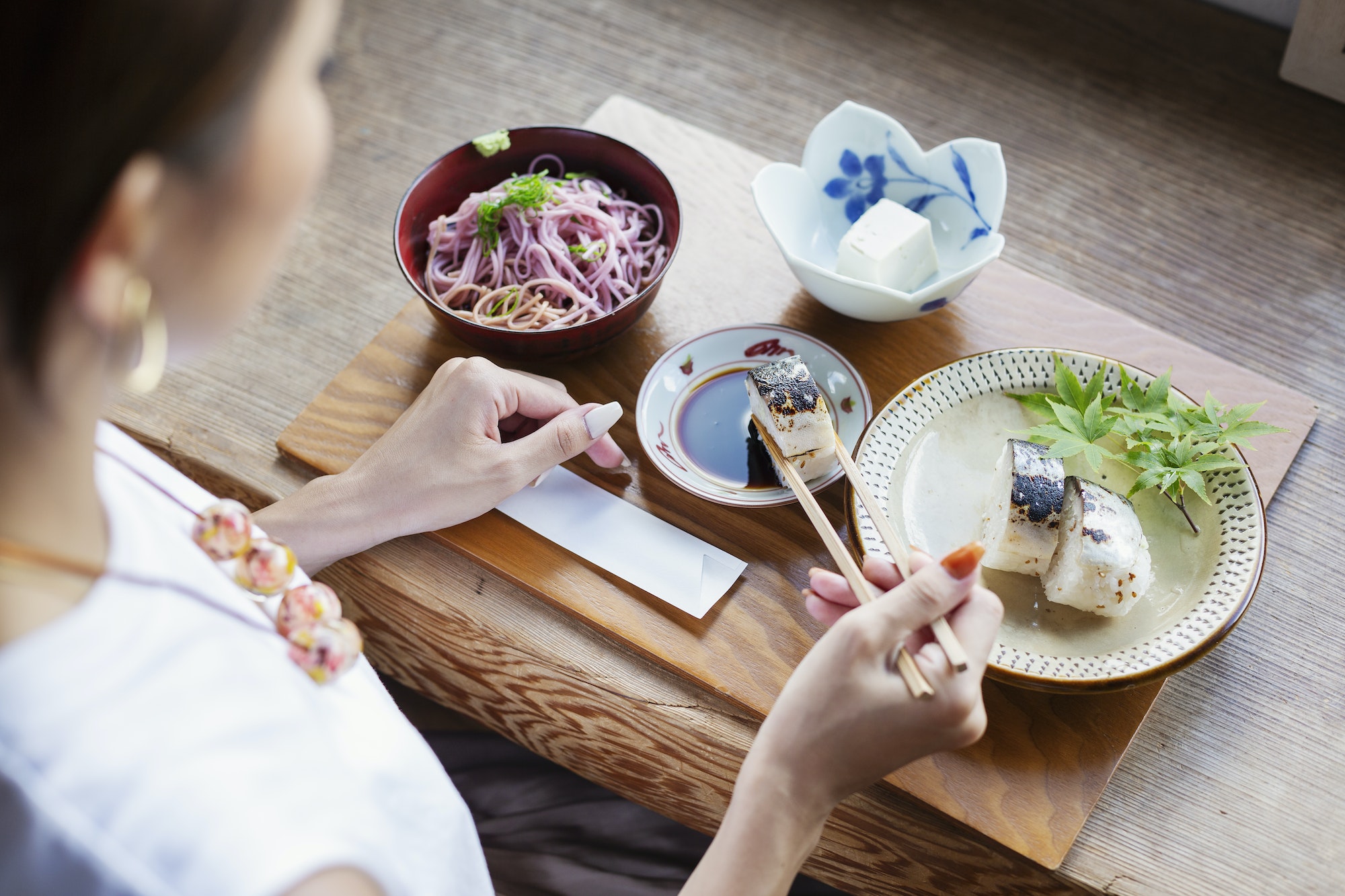 High angle view of Japanese woman sitting at a table in a Japanese restaurant, eating.